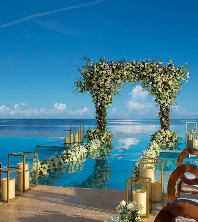 Floral arch at an infinity pool wedding ceremony at Dreams Natura, Riviera Maya