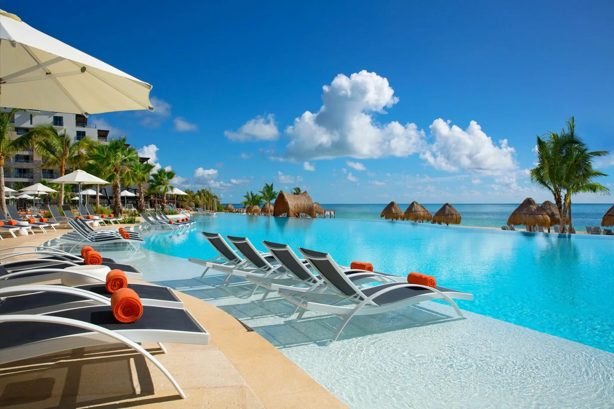 Dreams Natura infinity pool with submerged lounge chairs overlooking the Caribbean sea