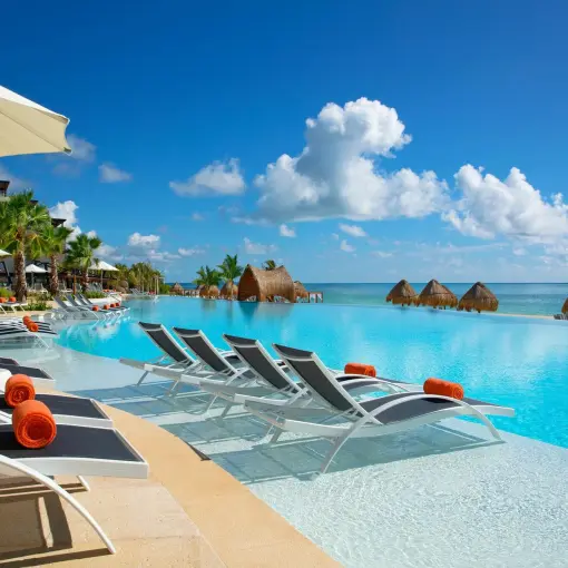 Dreams Natura infinity pool with lounge chairs and orange towels, Riviera Maya