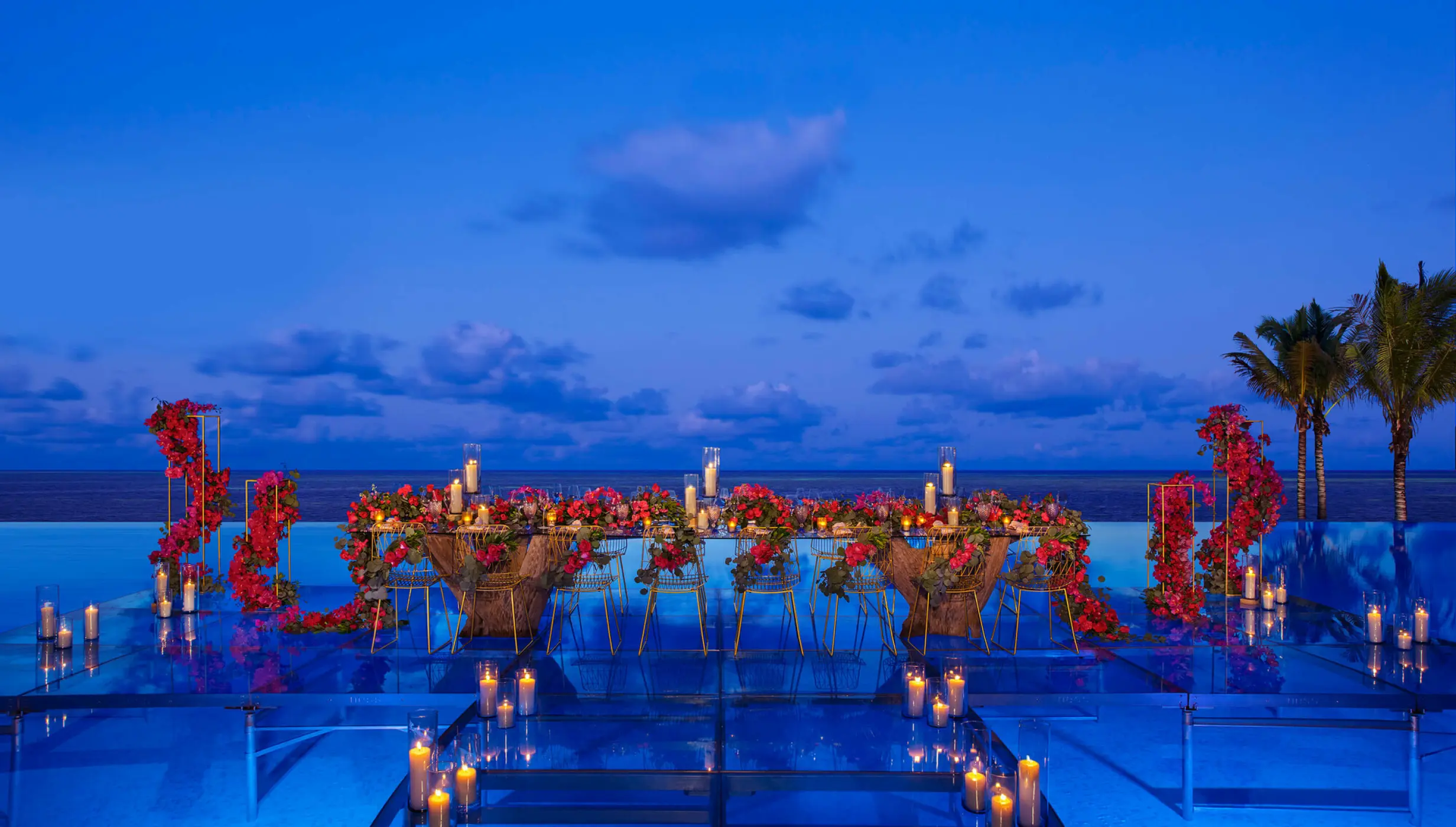 Evening wedding reception table with candles over the infinity pool at Dreams Natura, Riviera Maya