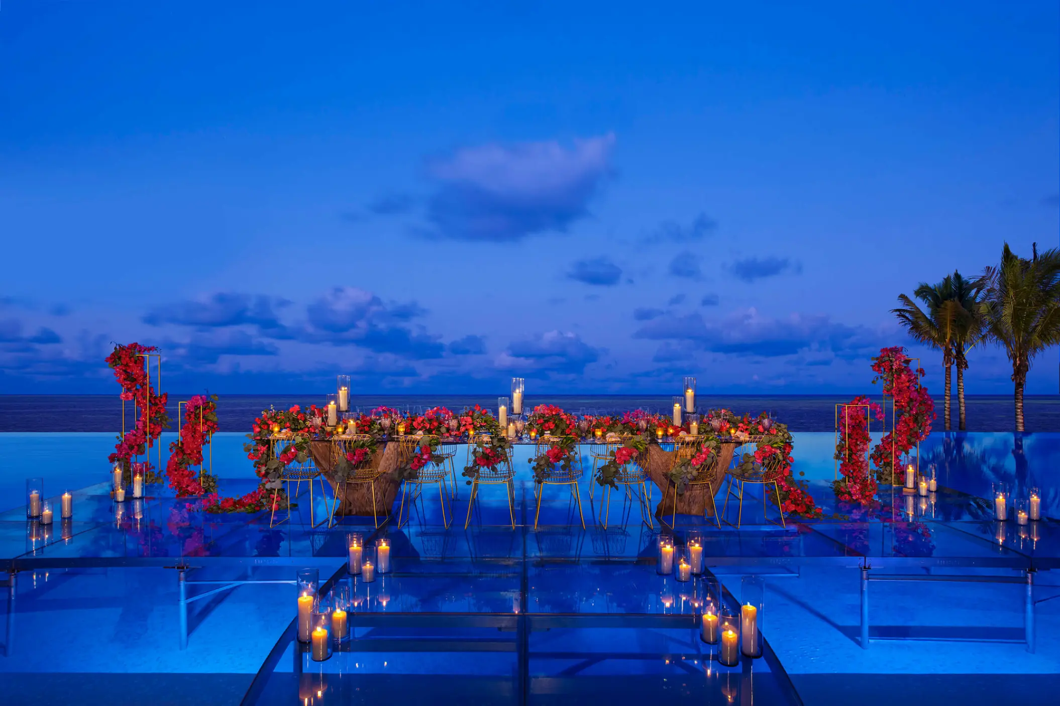 Evening wedding reception table with candles over the infinity pool at Dreams Natura, Riviera Maya