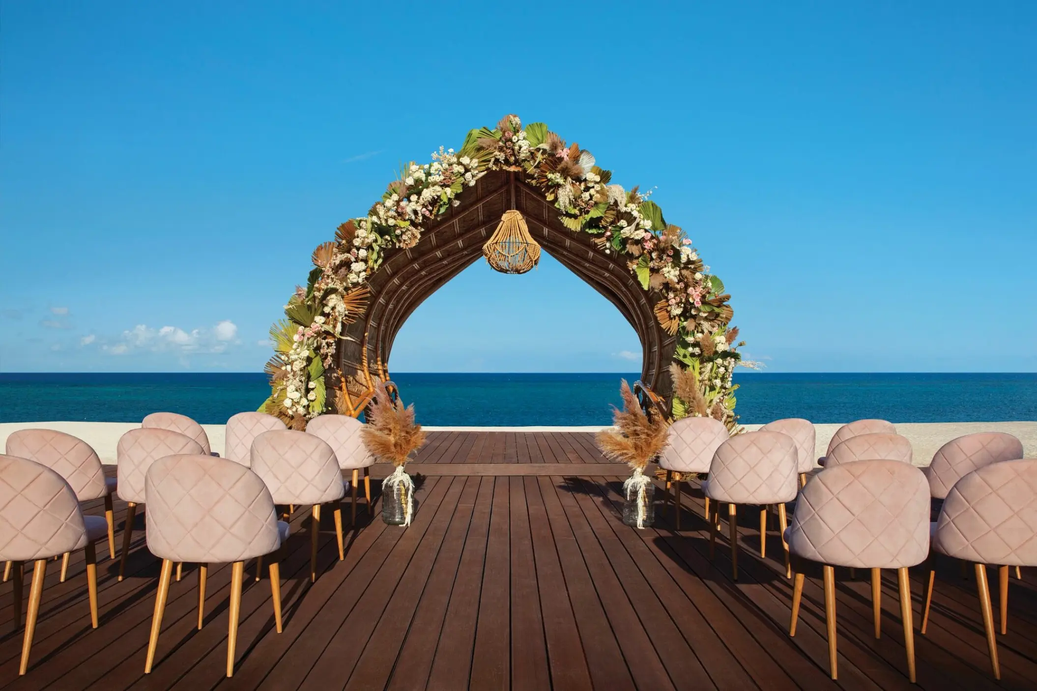 Floral arch at a beachfront wedding ceremony venue at Dreams Natura Riviera Maya
