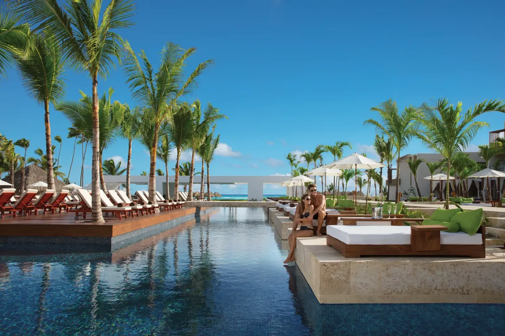 Adults-only pool area with lounge beds and palm trees at Dreams Onyx, Punta Cana