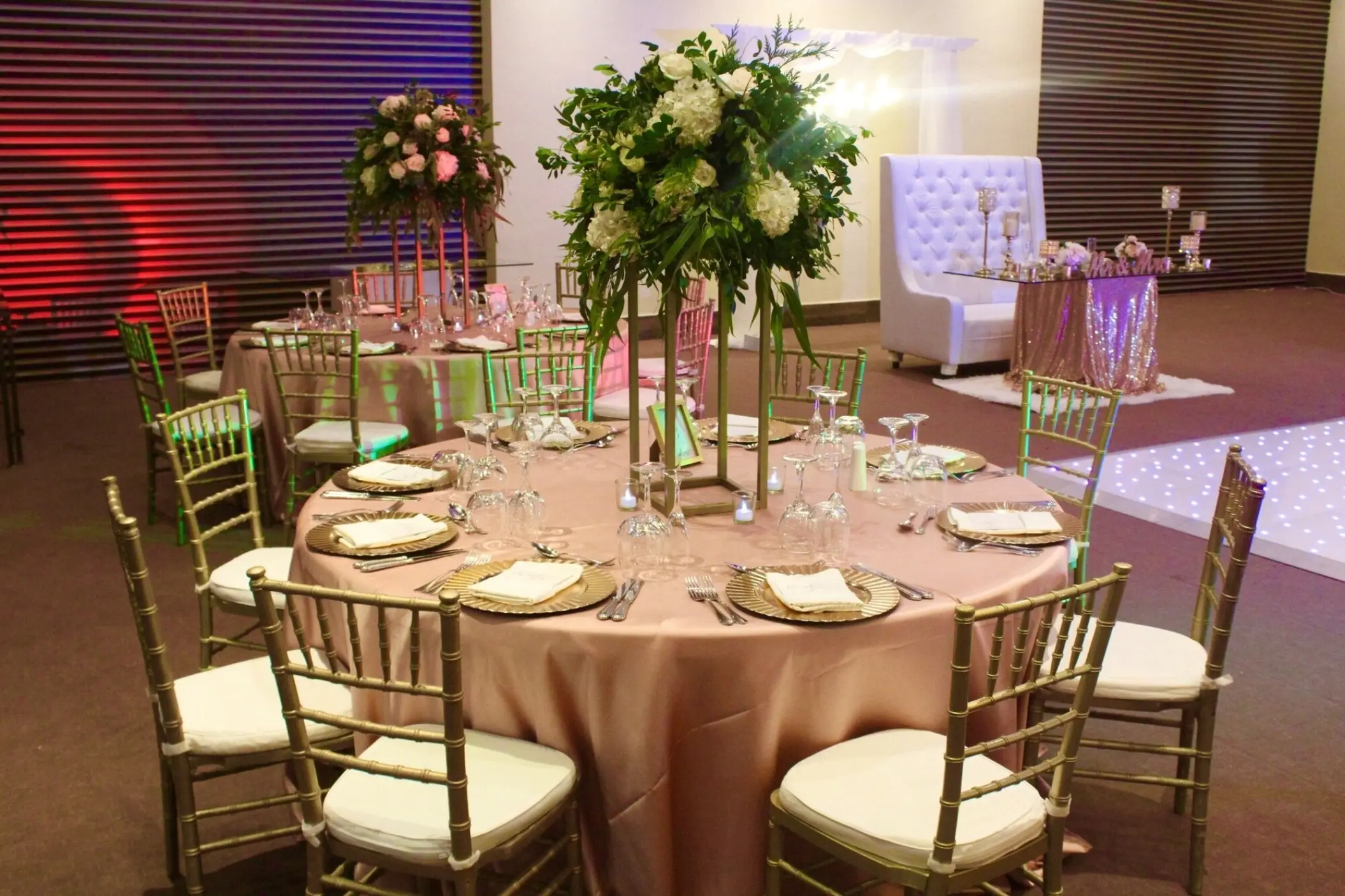 Indoor ballroom wedding reception with floral centerpieces and gold chairs at Dreams Onyx, Punta Cana