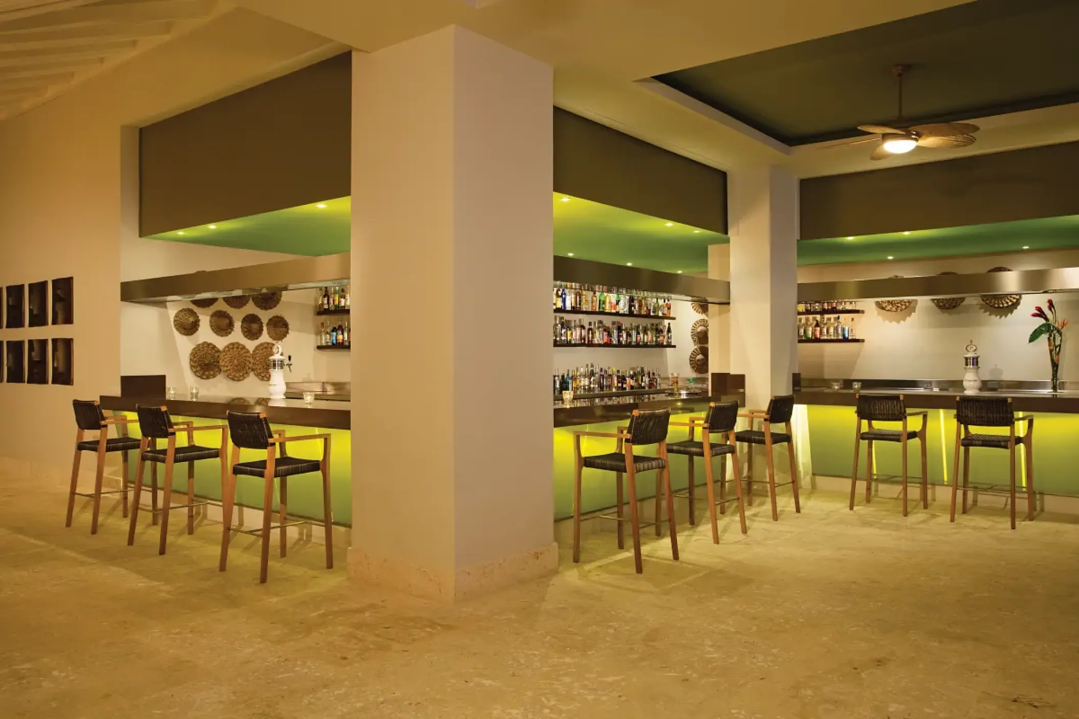 Modern indoor bar with neon green lighting and high wooden stools at Dreams Onyx, Punta Cana
