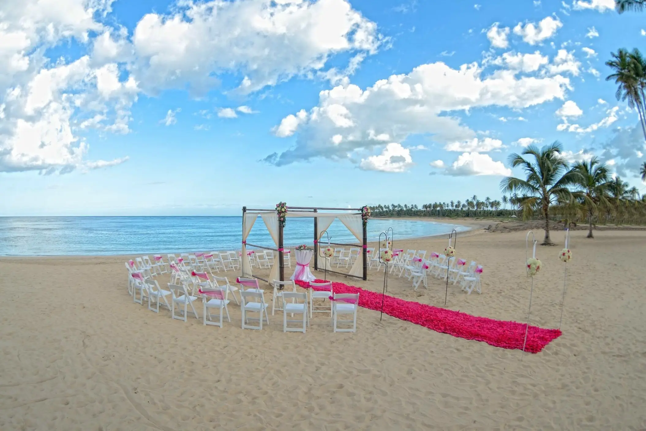 Beachfront wedding ceremony setup with pink runner at Dreams Onyx, Punta Cana