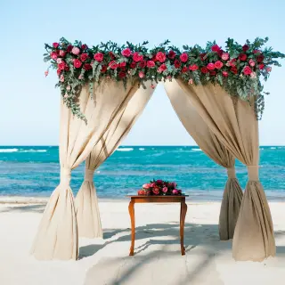 Beachfront wedding ceremony arch with pink flowers at Dreams Onyx, Punta Cana