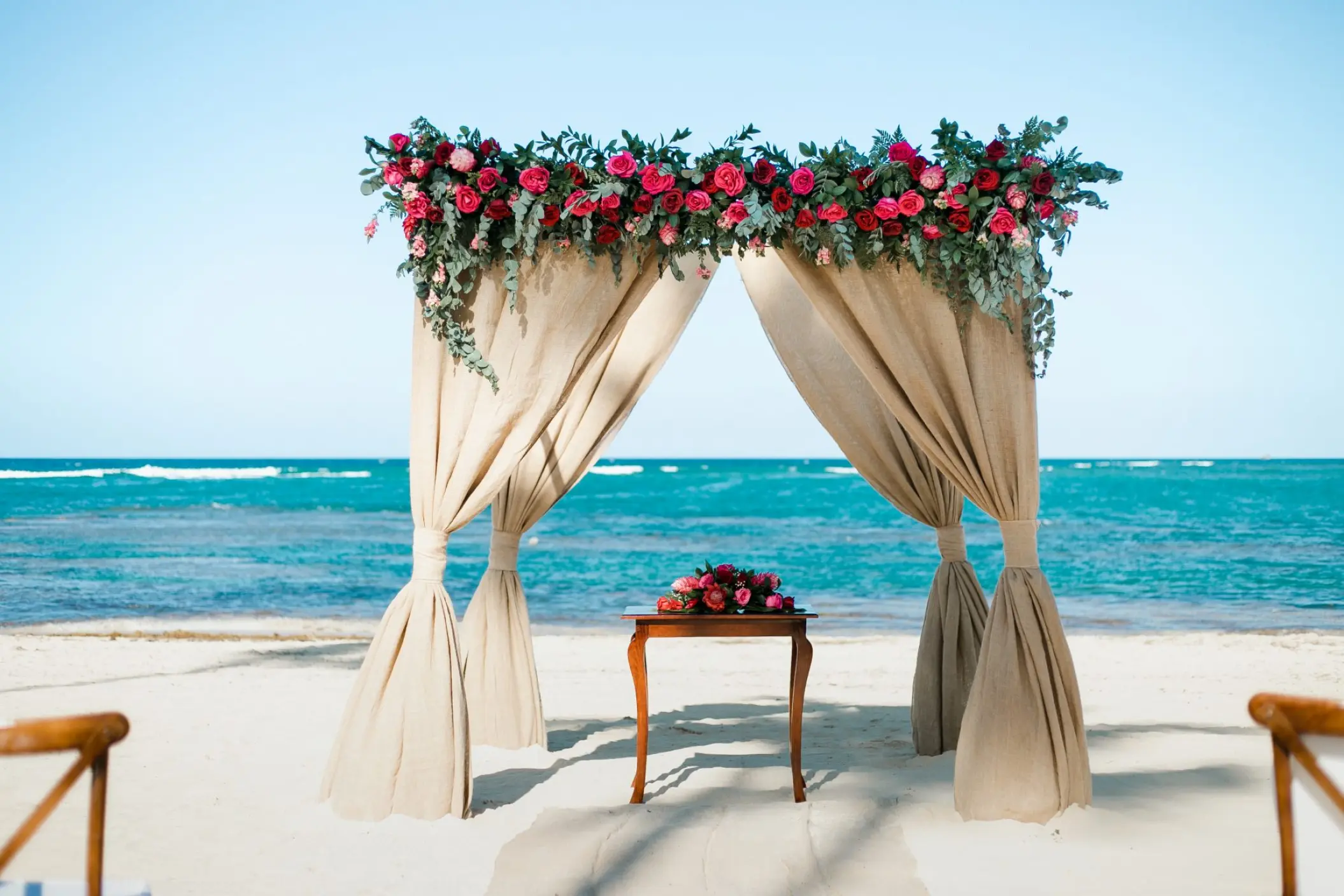 Beachfront wedding ceremony arch with pink flowers at Dreams Onyx, Punta Cana