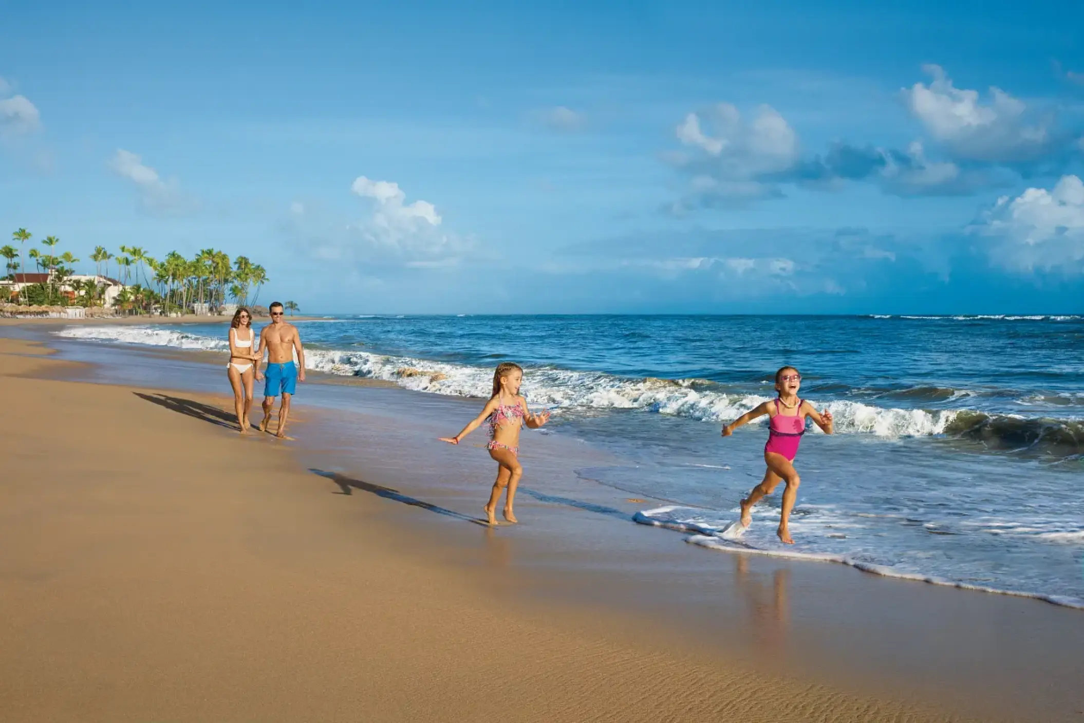 Family playing in the surf on the beach at Dreams Onyx, Punta Cana