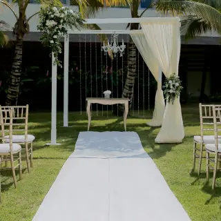 Garden wedding ceremony setup with white aisle runner and gazebo at Dreams Onyx, Punta Cana