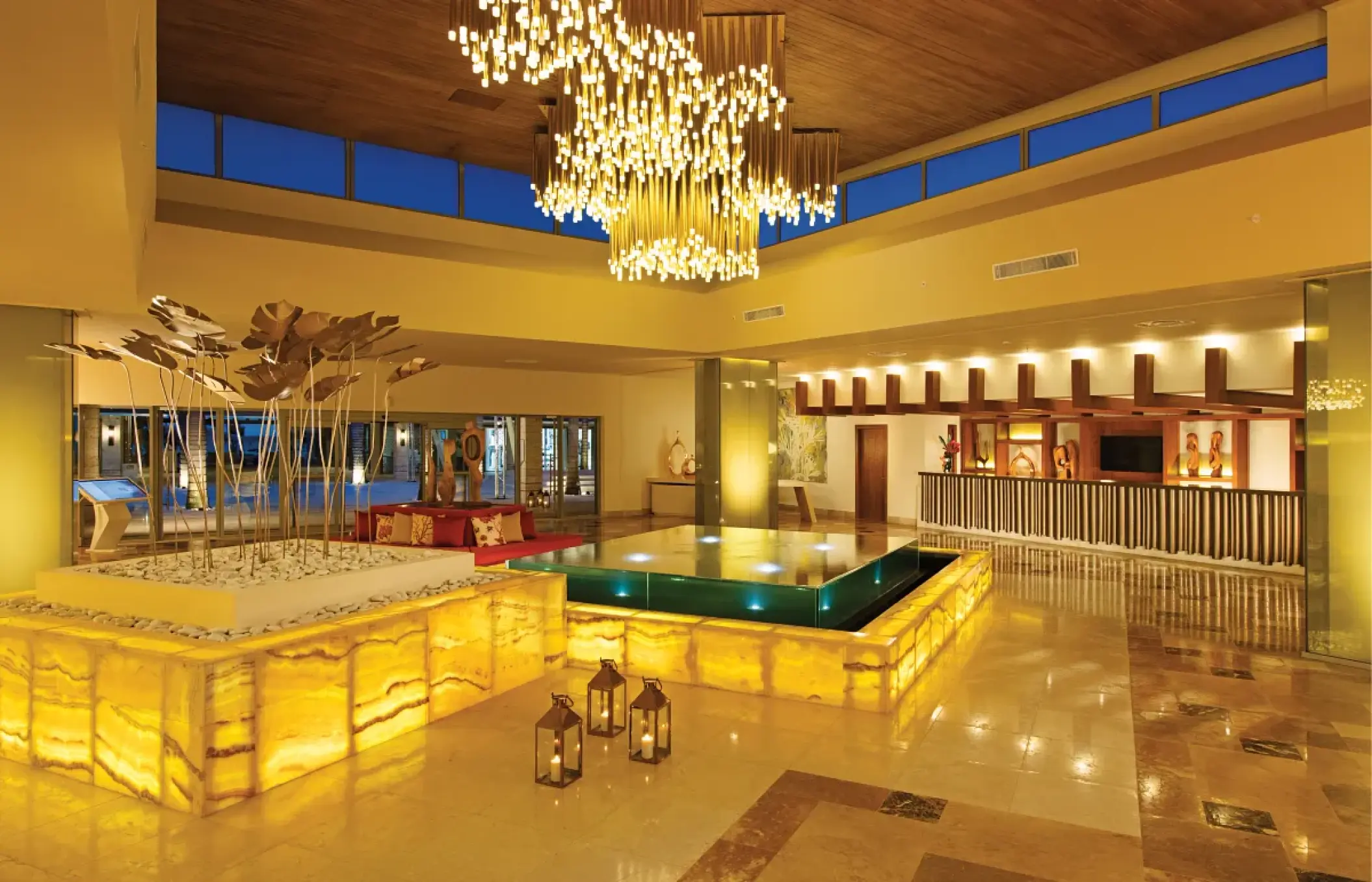 Dreams Onyx lobby featuring glowing stone counters and a large modern chandelier, Punta Cana