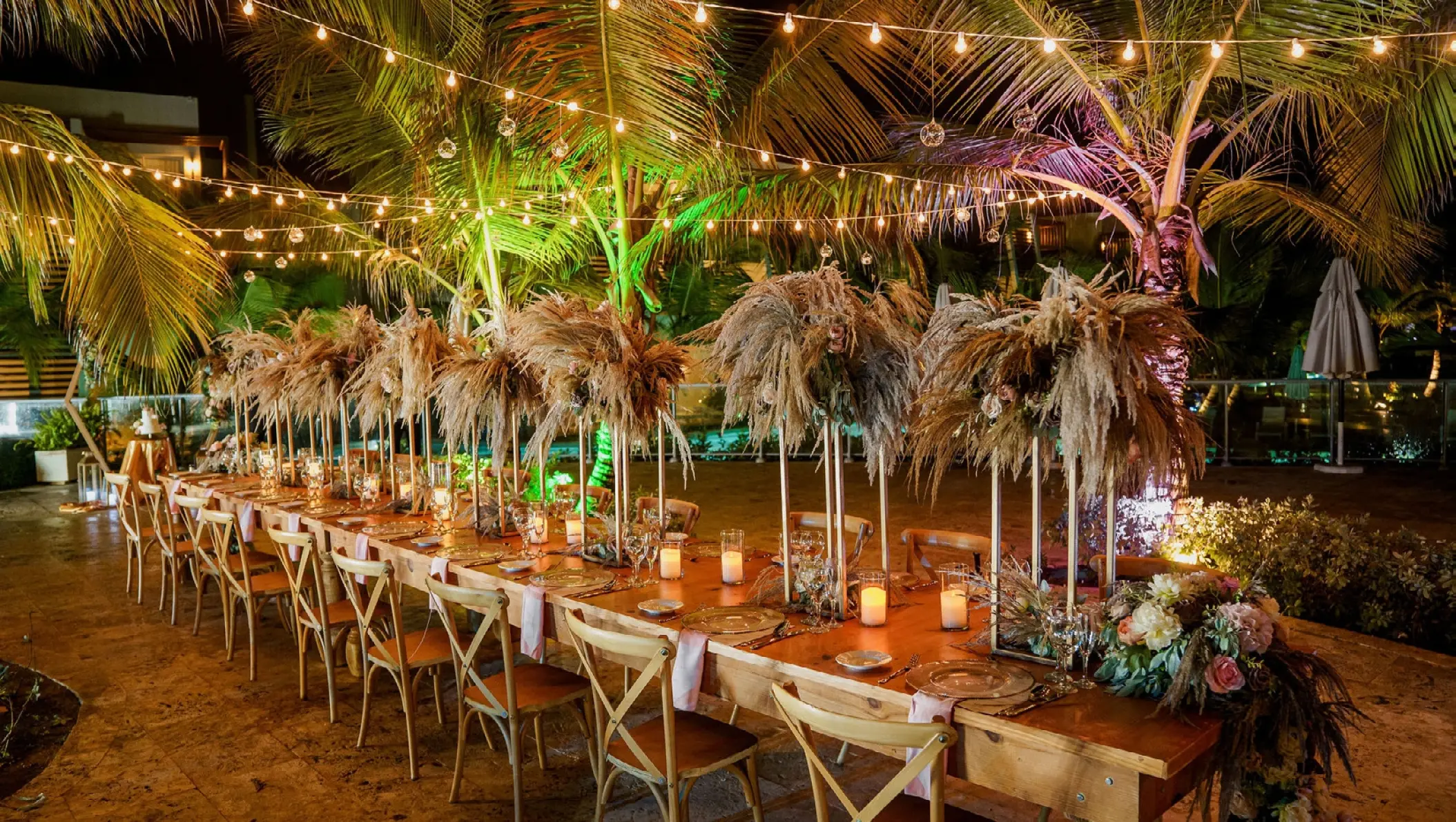 Outdoor wedding reception with string lights and floral centerpieces at Dreams Onyx, Punta Cana
