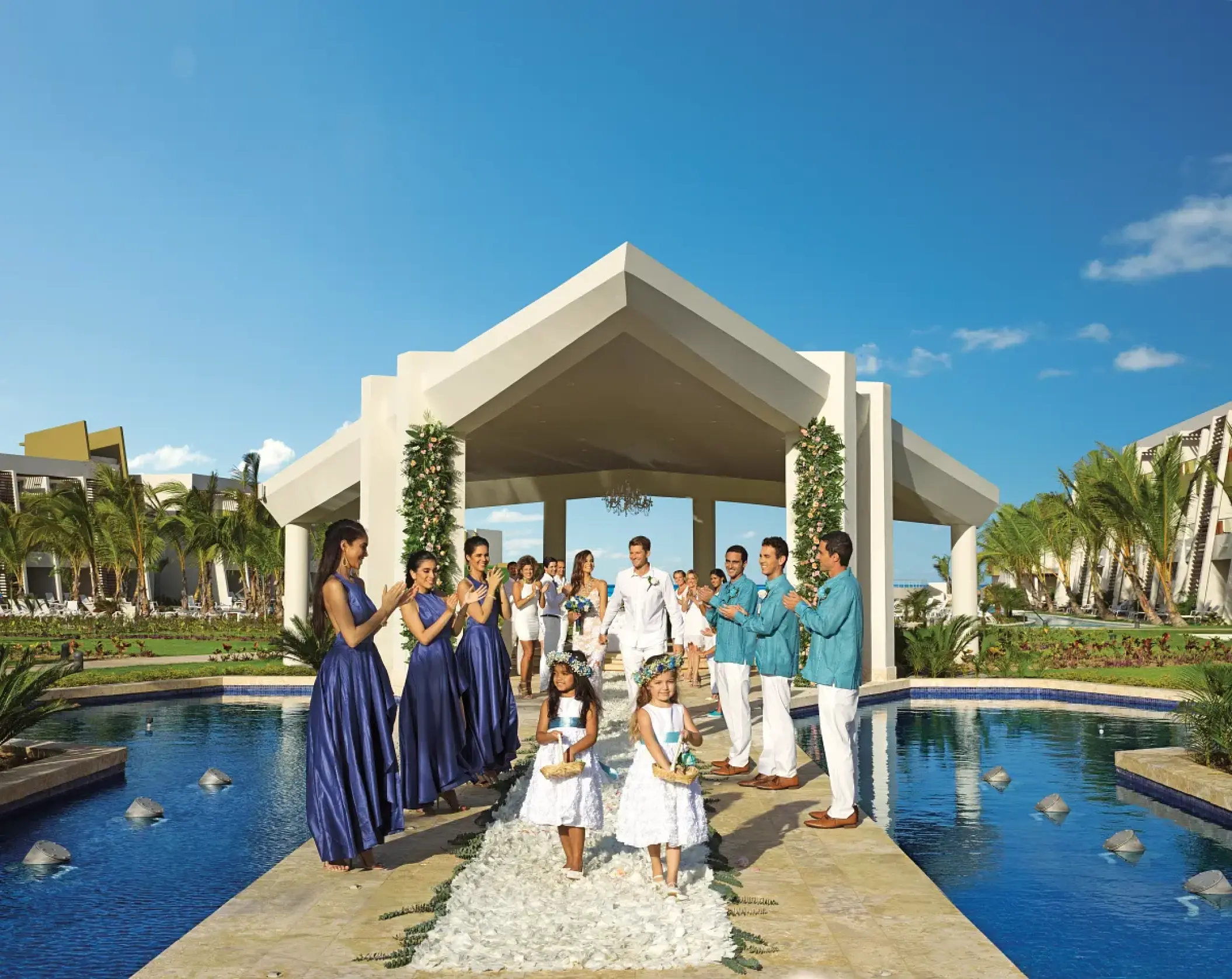 Wedding party walking from the garden gazebo ceremony site at Dreams Onyx, Punta Cana