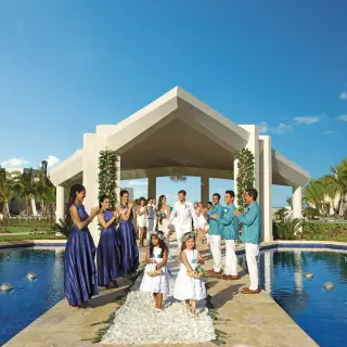 Wedding party walking from the garden gazebo ceremony site at Dreams Onyx, Punta Cana