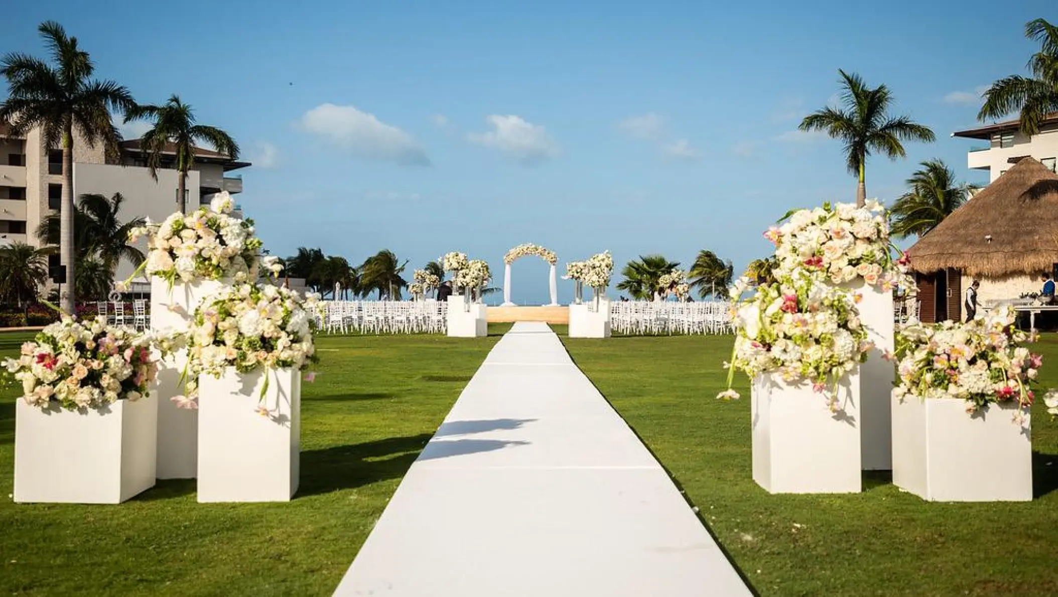 Central garden wedding ceremony setup with floral pillars at Dreams Playa Mujeres, Cancun