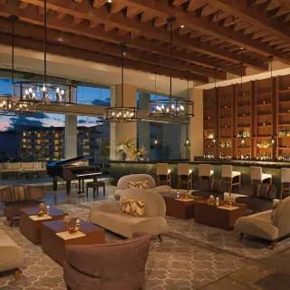 Indoor lobby bar with lounge seating and grand piano at Dreams Playa Mujeres, Cancun