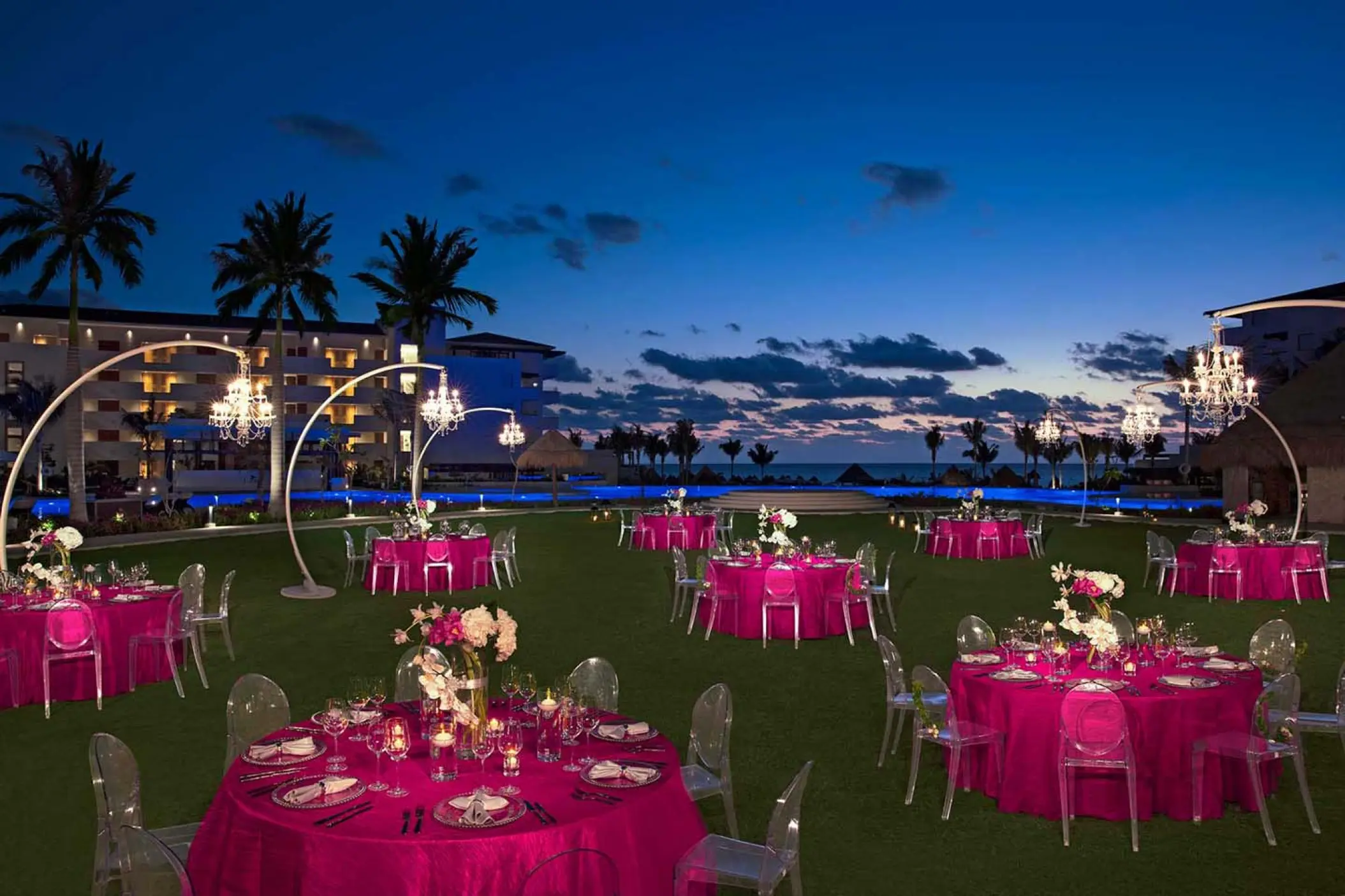 Evening wedding reception with pink linens on the lawn at Dreams Playa Mujeres, Cancun