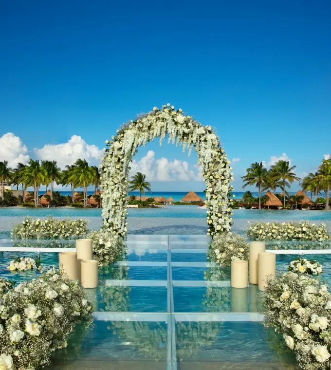 Floral arch on a glass platform over the pool for a wedding ceremony at Dreams Playa Mujeres, Cancun