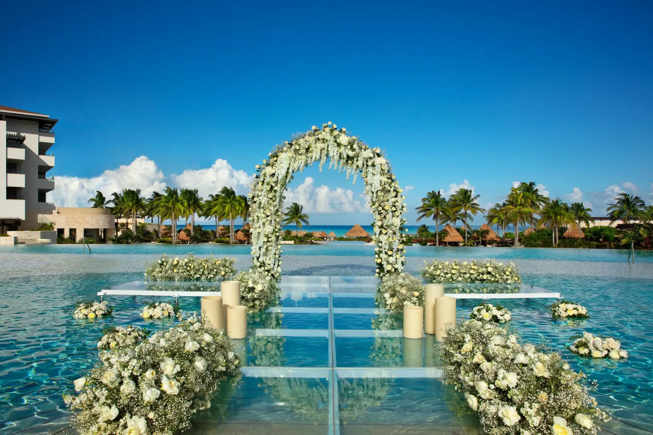 Floral arch on a glass platform over the pool for a wedding ceremony at Dreams Playa Mujeres, Cancun