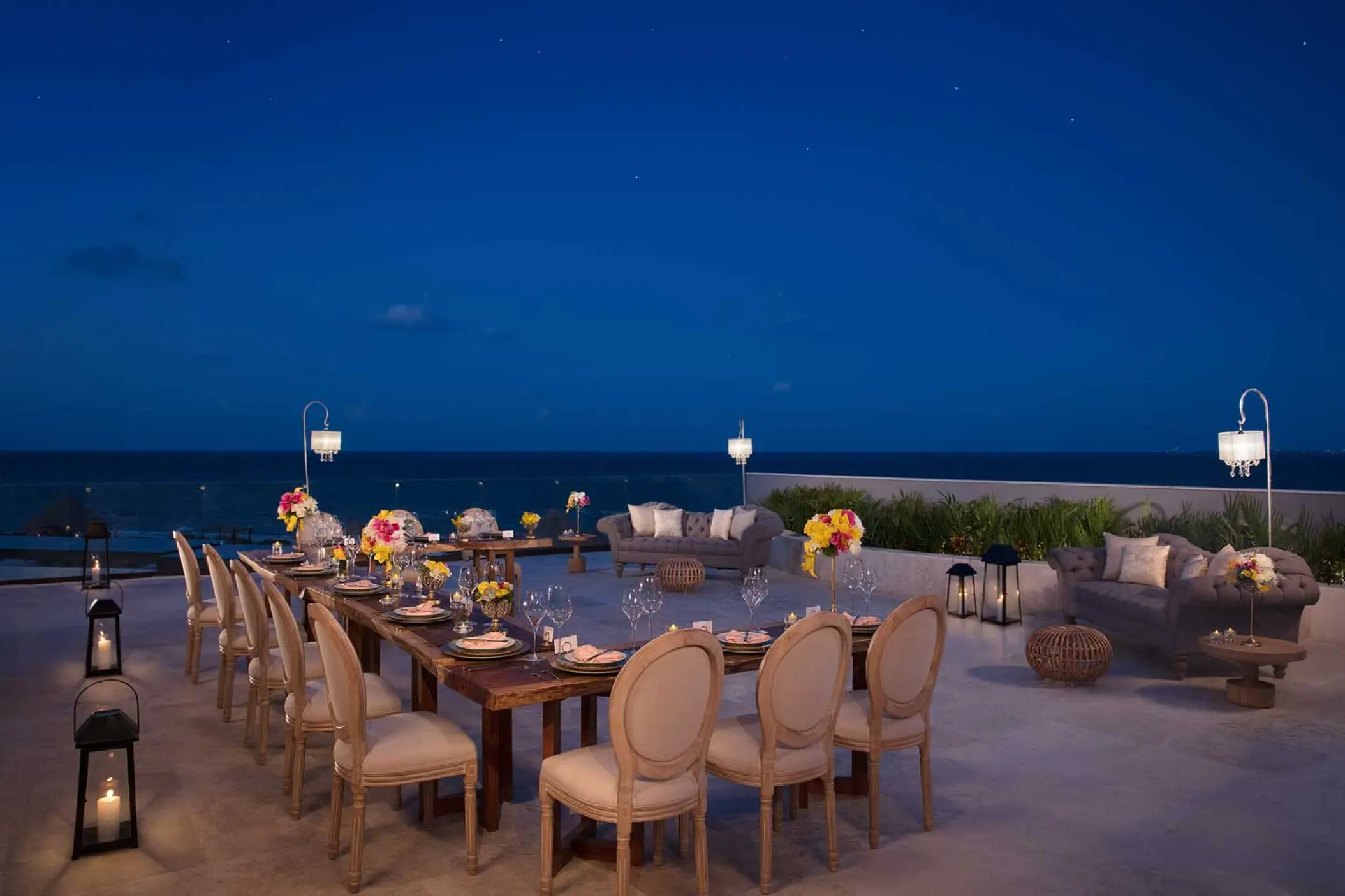 Terrace wedding reception with candle lanterns and ocean views at Dreams Playa Mujeres, Cancun