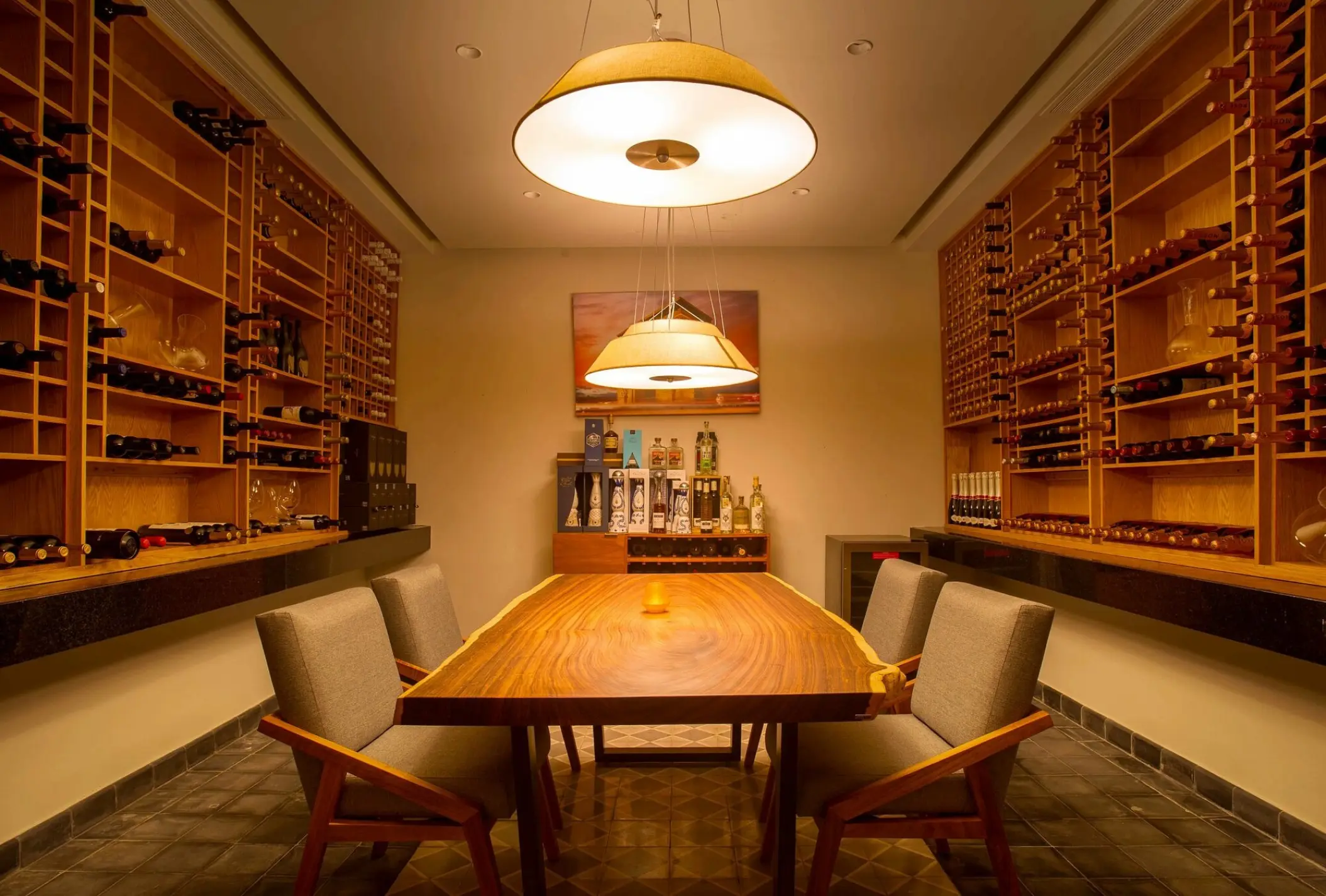 Private wine cellar dining room with wooden table and wall-to-wall wine racks at Dreams Playa Mujeres, Cancun