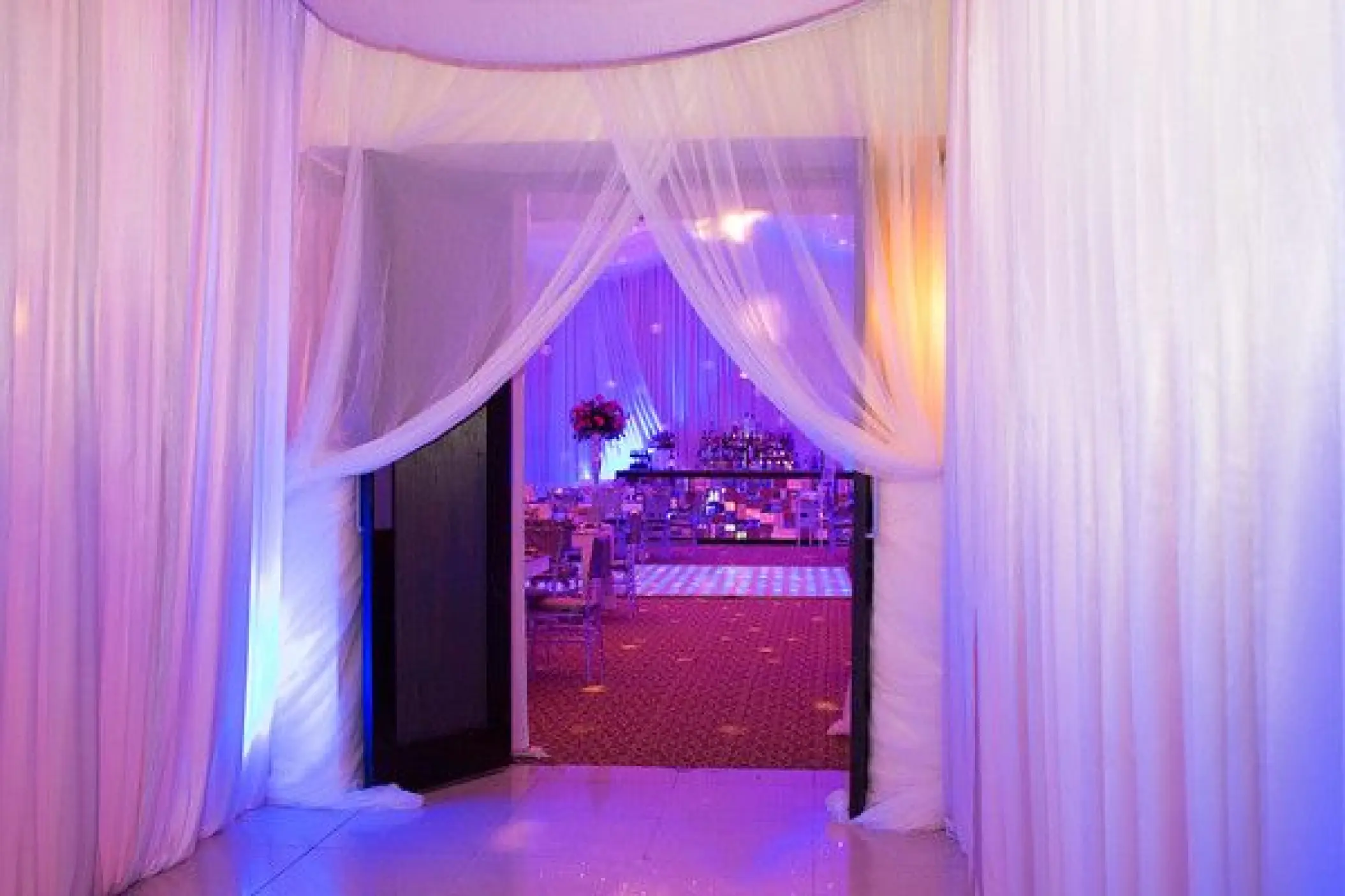 Draped ballroom wedding reception entrance with purple lighting at Dreams Riviera Cancun, Riviera Maya