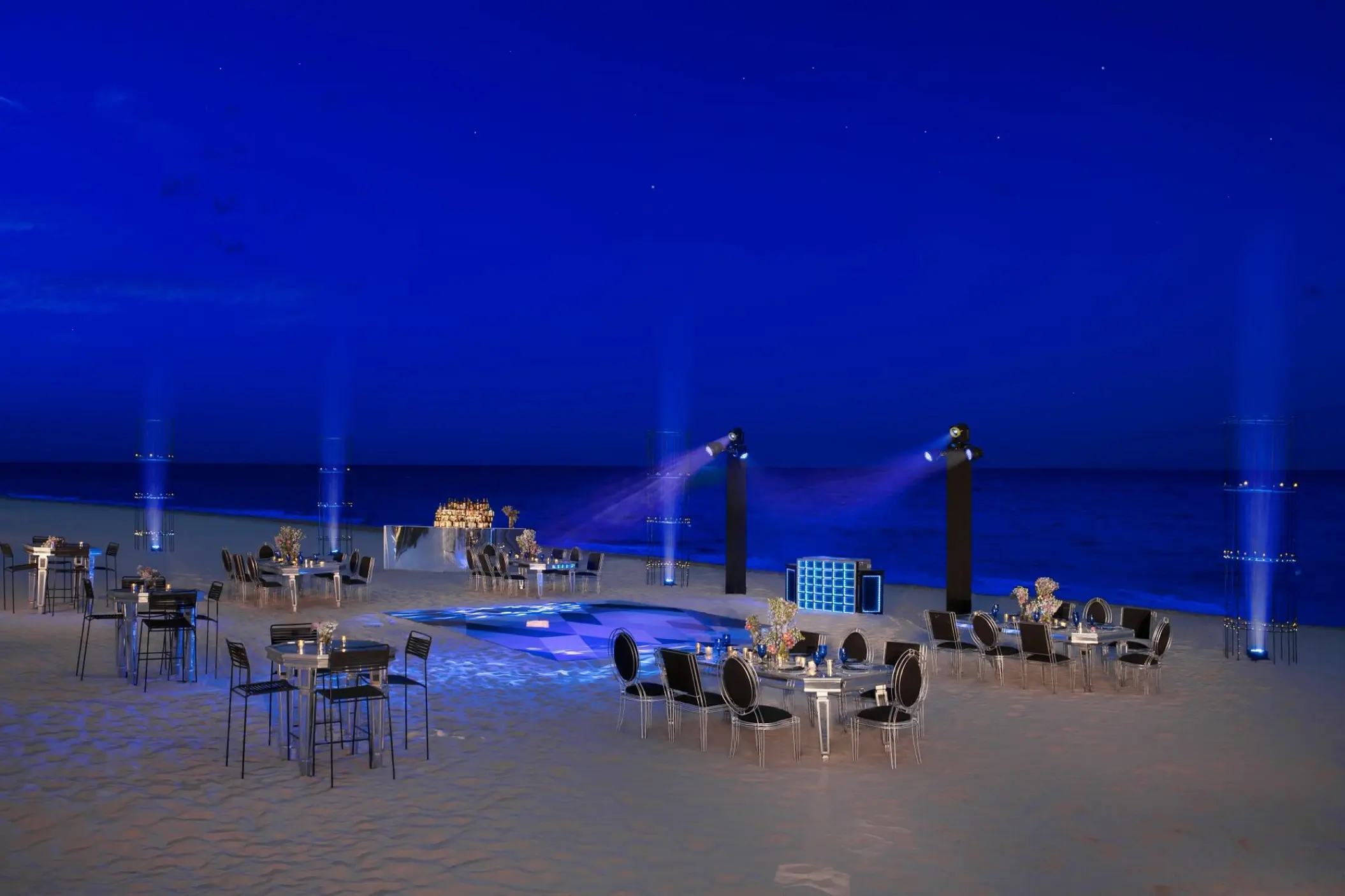 Nighttime beach reception with blue event lighting and dance floor at Dreams Riviera Cancun, Riviera Maya