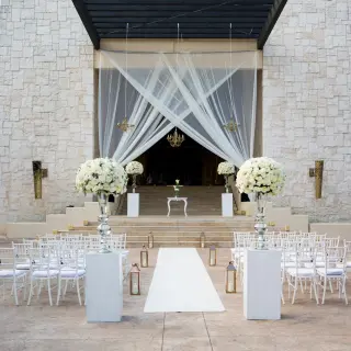 Grand Staircase wedding ceremony setup with white floral pillars at Dreams Riviera Cancun, Riviera Maya