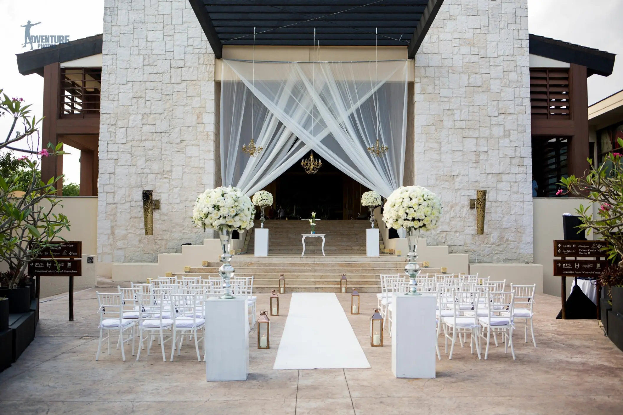 Grand Staircase wedding ceremony setup with white floral pillars at Dreams Riviera Cancun, Riviera Maya