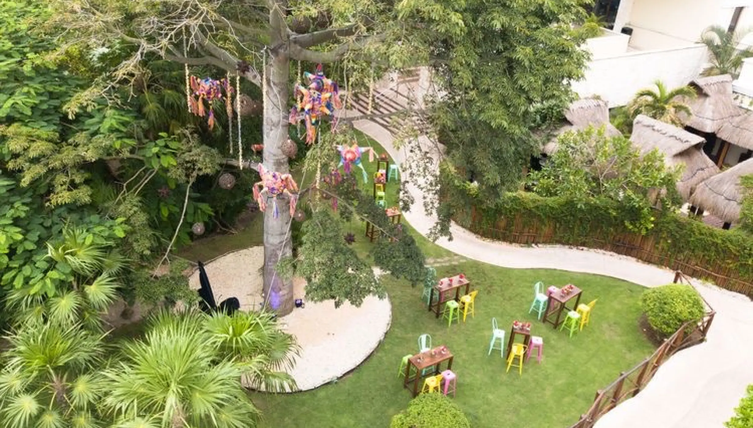 Ceiba tree wedding venue with colorful piñatas and cocktail tables at Dreams Riviera Cancun, Riviera Maya