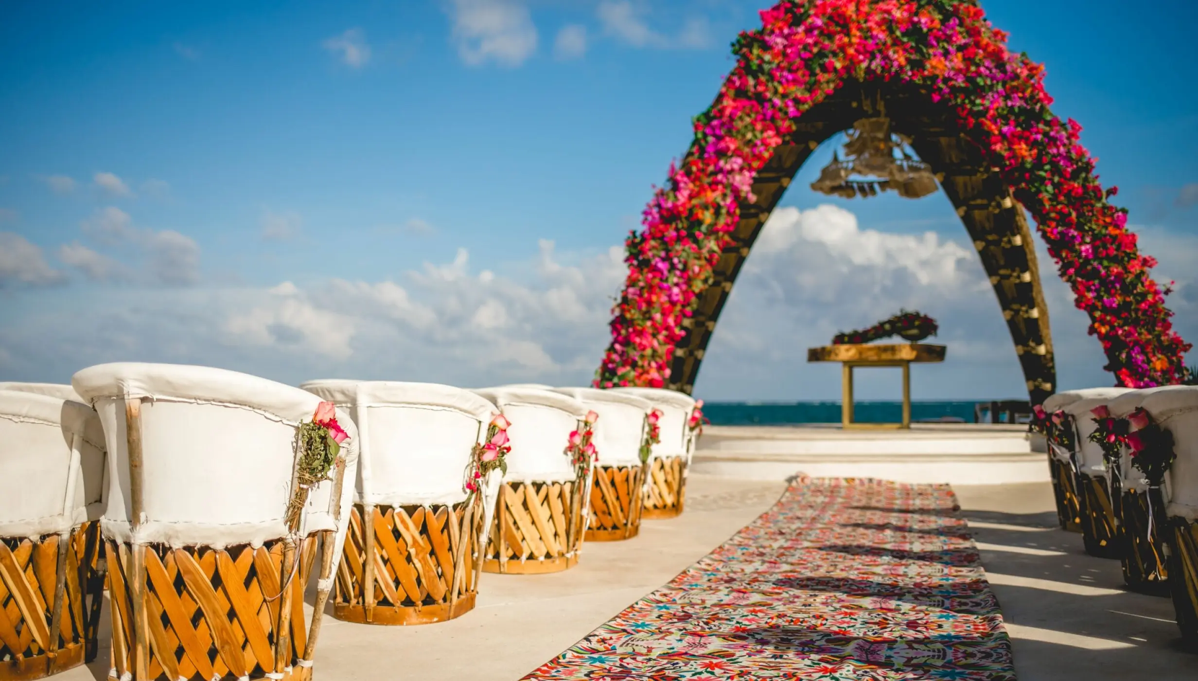 Floral wedding ceremony arch and equipal chairs at Dreams Riviera Cancun, Riviera Maya