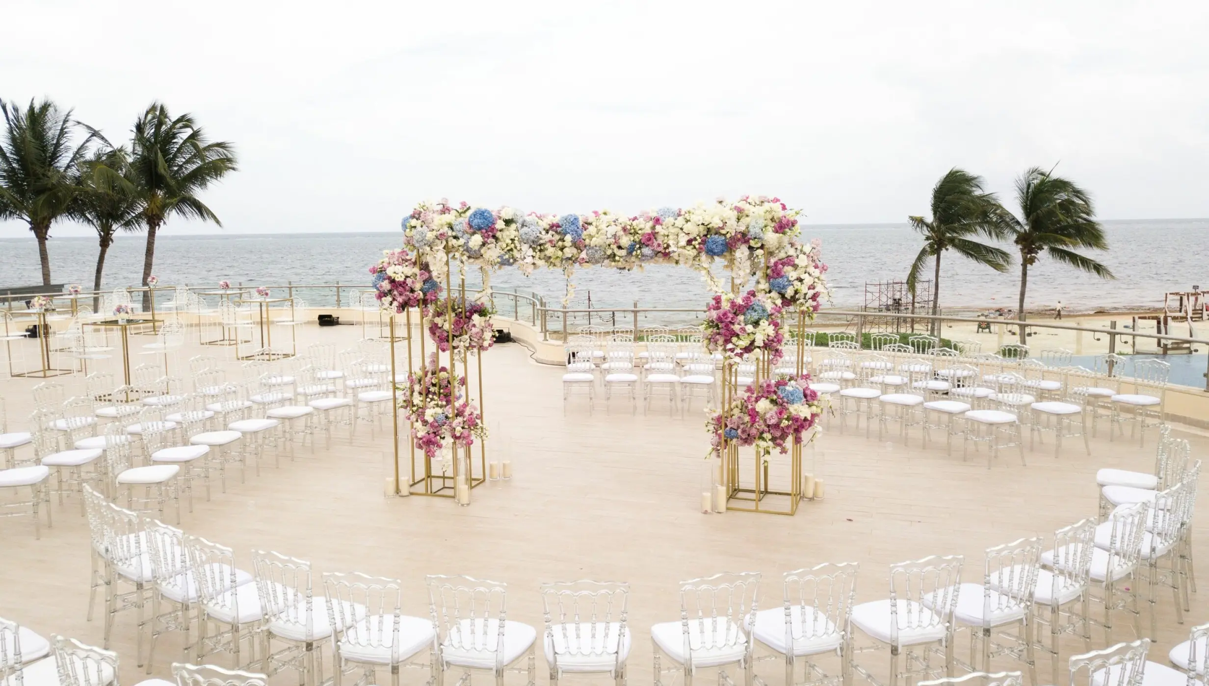 Outdoor wedding ceremony with a floral arch and circular seating at Dreams Riviera Cancun, Riviera Maya