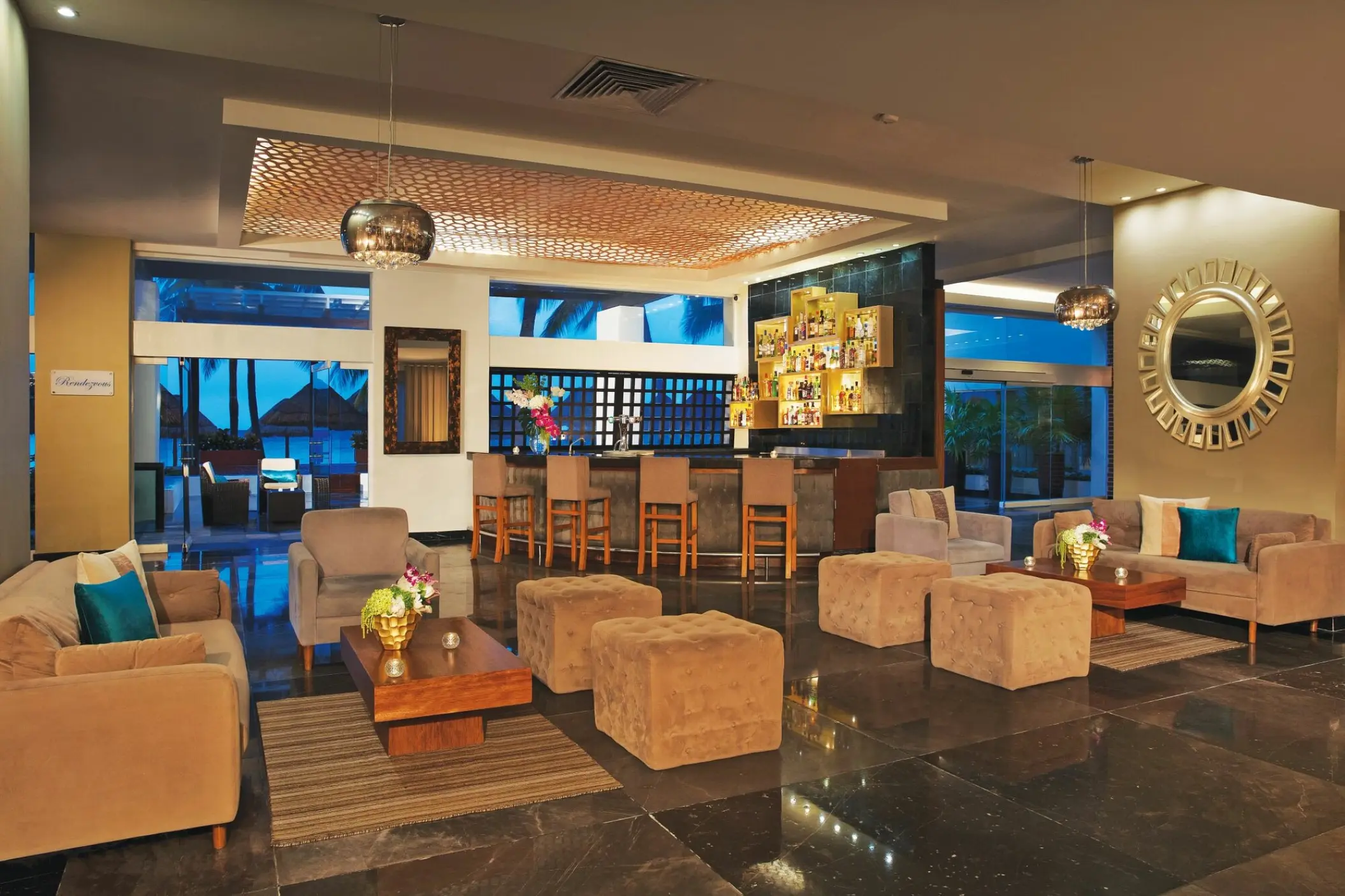 Modern indoor lounge and bar area with plush seating at Dreams Sands Cancun, Cancun