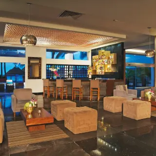 Modern indoor lounge and bar area with plush seating at Dreams Sands Cancun, Cancun