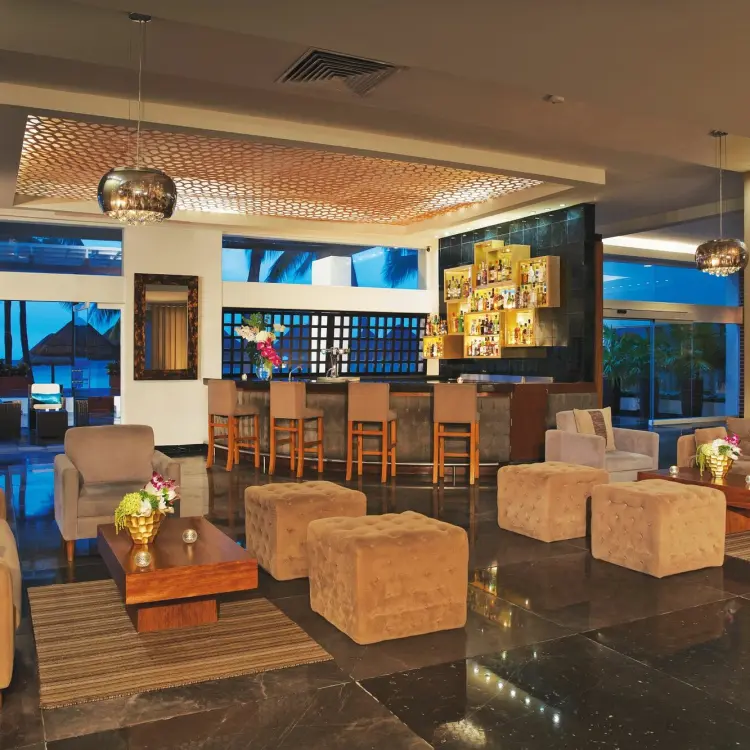 Modern indoor lounge and bar area with plush seating at Dreams Sands Cancun, Cancun