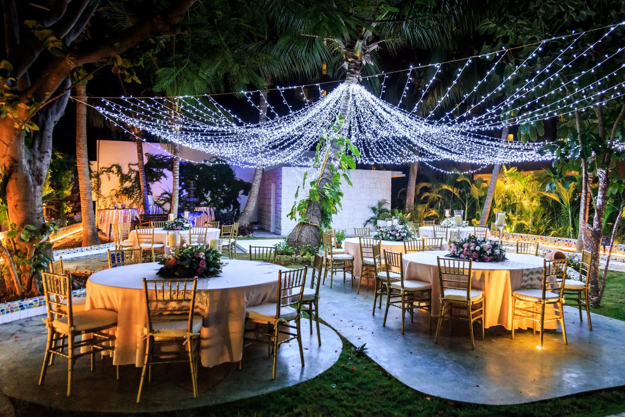 Garden wedding reception under string lights at Dreams Sands Cancun