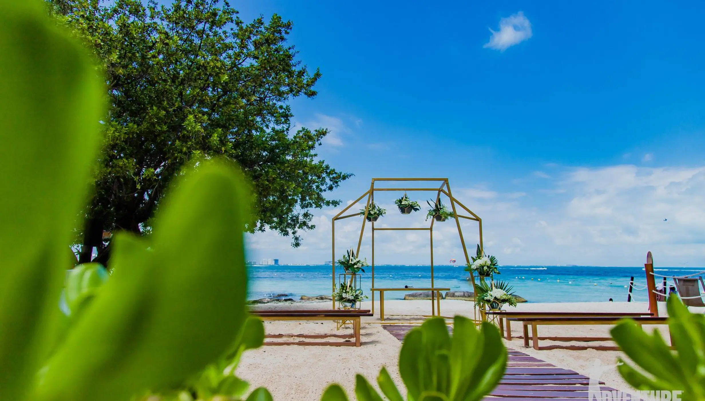 Beachfront wedding ceremony setup with a gold arch at Dreams Sands Cancun, Cancun