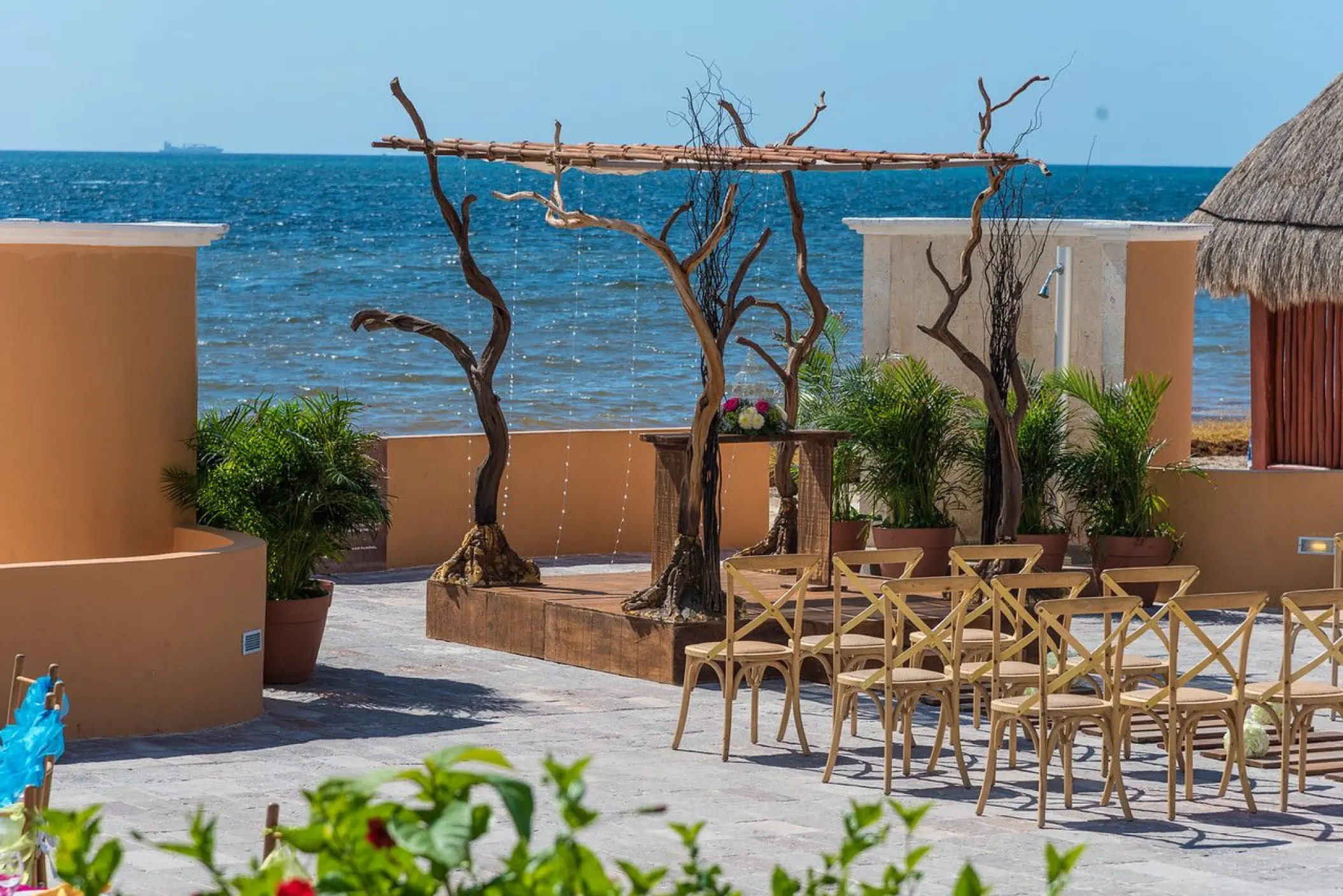 Terrace wedding ceremony with rustic wooden arch at Dreams Sapphire, Riviera Maya