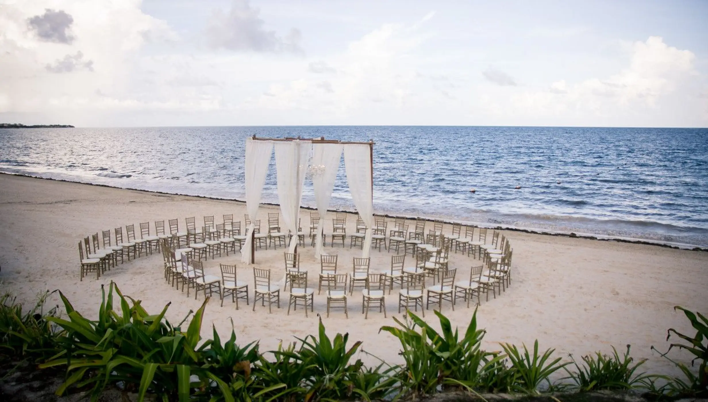 Beachfront wedding ceremony with circular seating at Dreams Sapphire, Riviera Maya