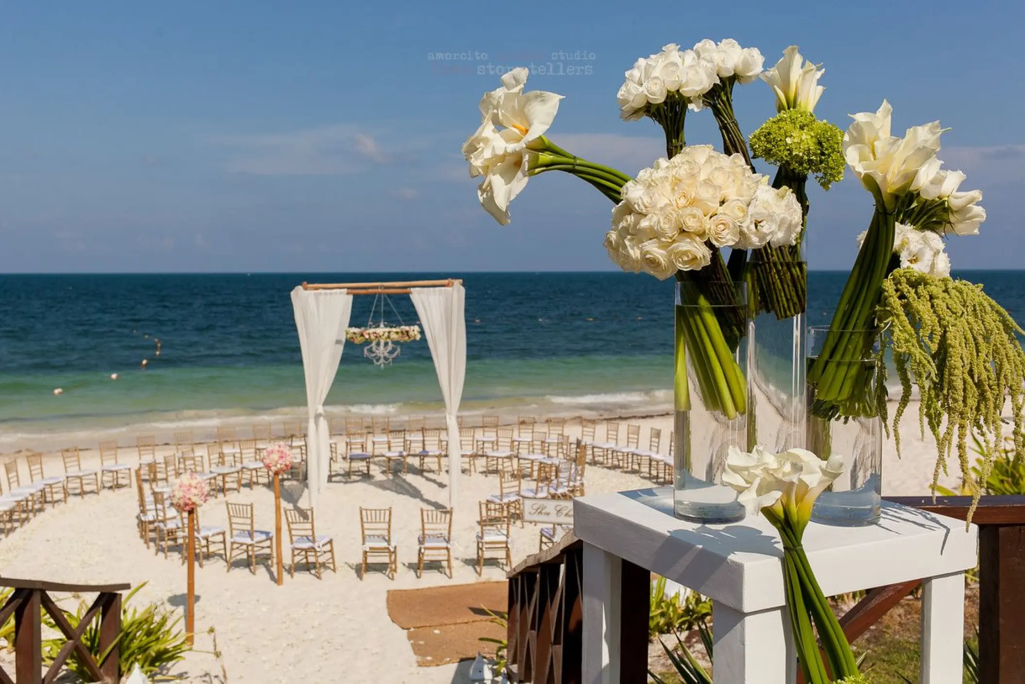 Beachfront wedding ceremony with circular seating and white floral arrangements at Dreams Sapphire, Riviera Maya