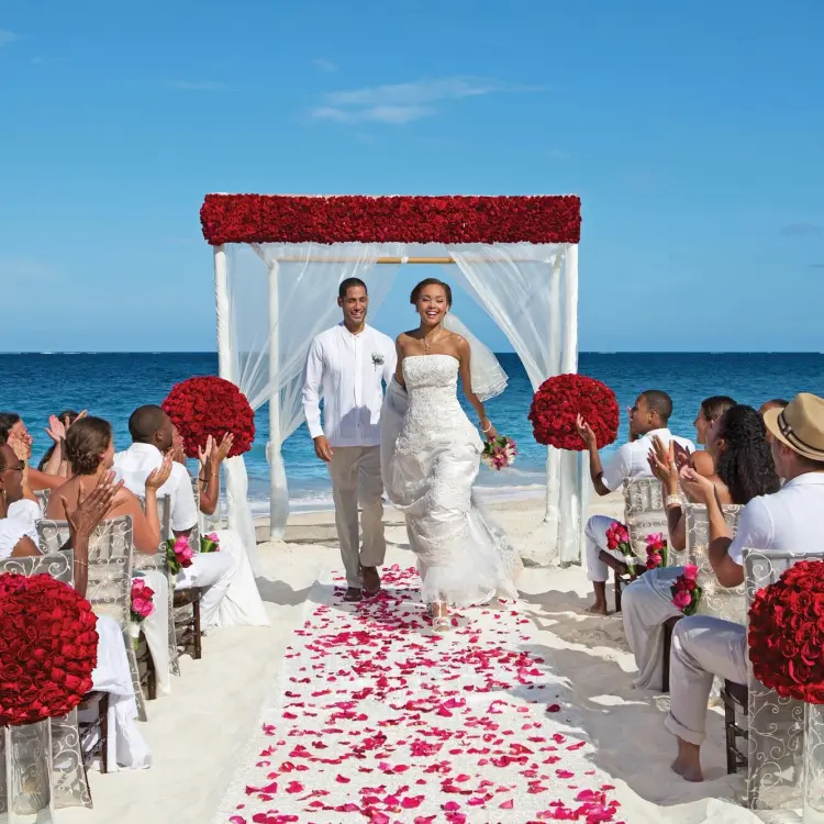 The couple walking down the aisle at a Dreams Sapphire beach ceremony, Riviera Maya