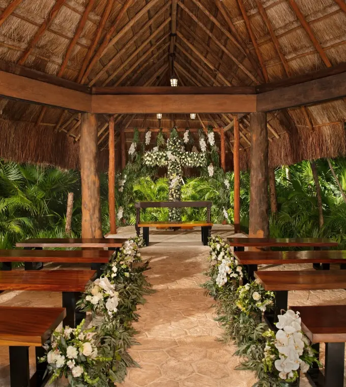 Thatched roof chapel with wooden benches for a wedding ceremony at Dreams Sapphire, Riviera Maya