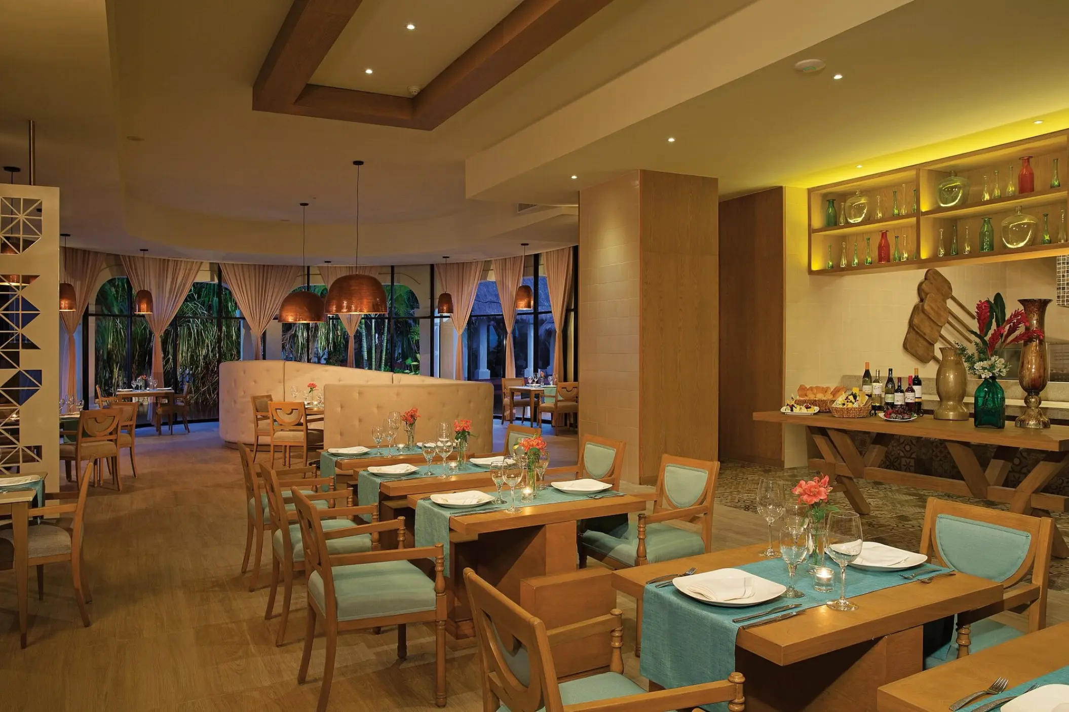 Cibu restaurant dining room with teal chairs and set tables at Dreams Sapphire, Riviera Maya