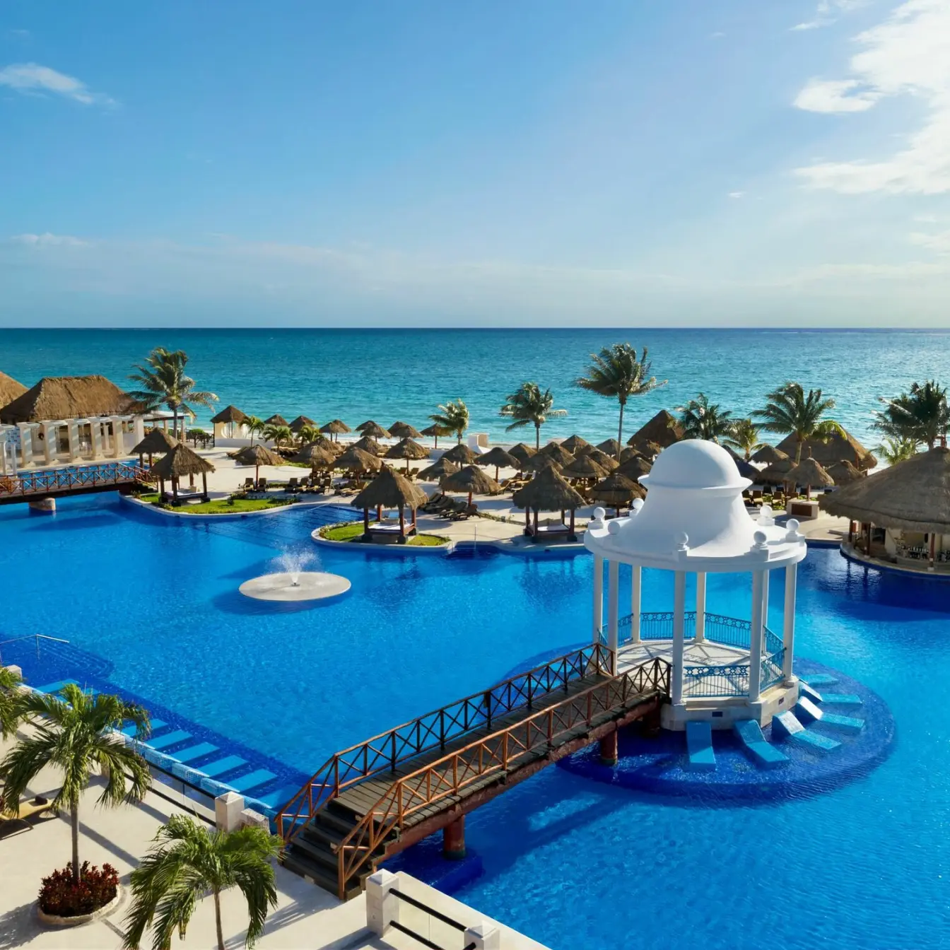 Dreams Sapphire main pool with a white gazebo and footbridge overlooking the ocean, Riviera Maya
