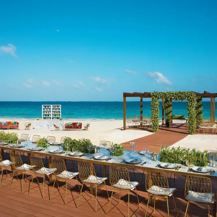 Beachfront wedding reception setup on a wooden terrace at Dreams Sapphire, Riviera Maya