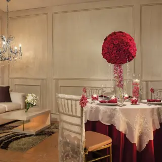 Indoor wedding reception table with a red floral centerpiece at Dreams Sapphire, Riviera Maya
