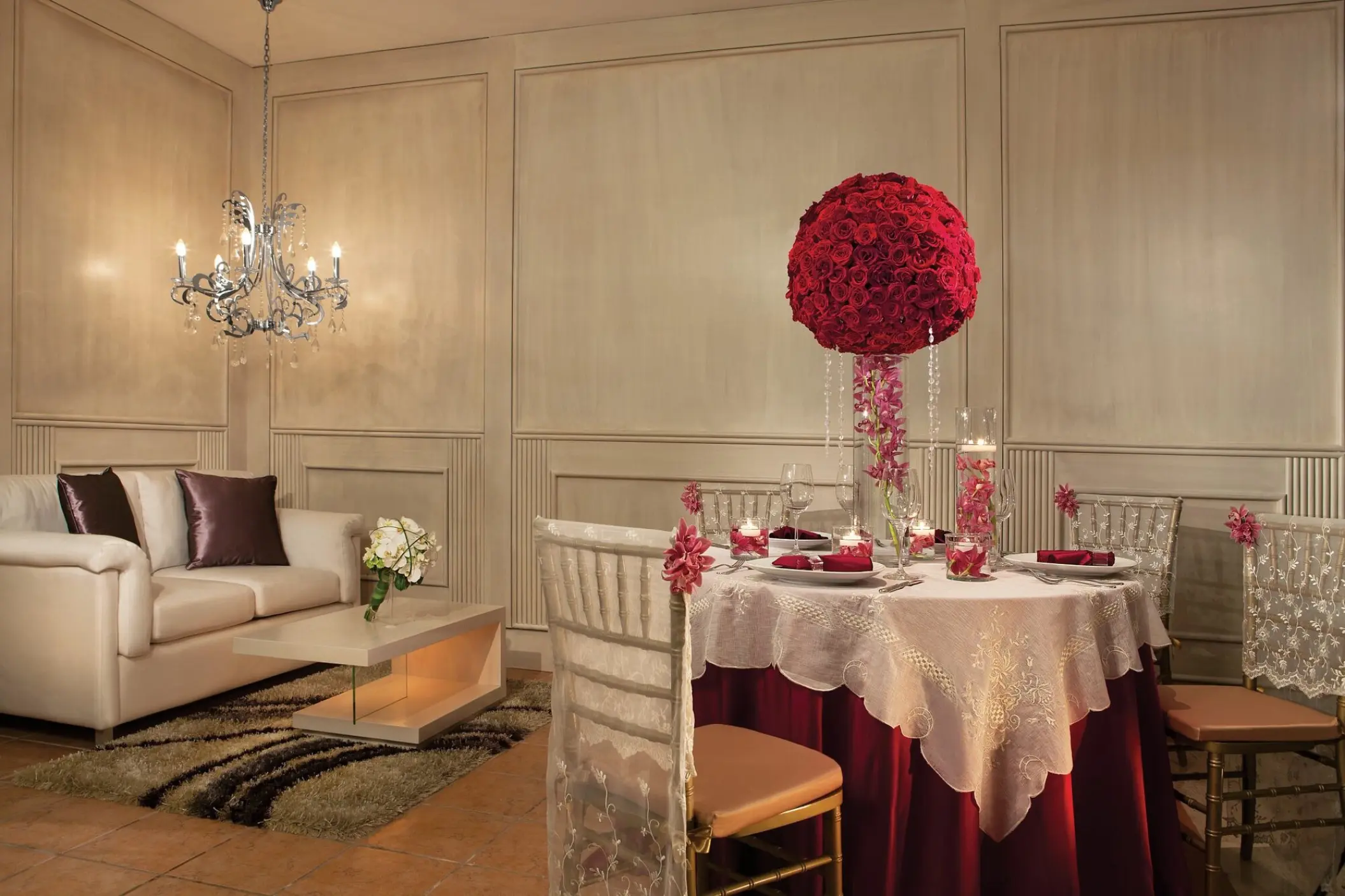 Indoor wedding reception table with a red floral centerpiece at Dreams Sapphire, Riviera Maya