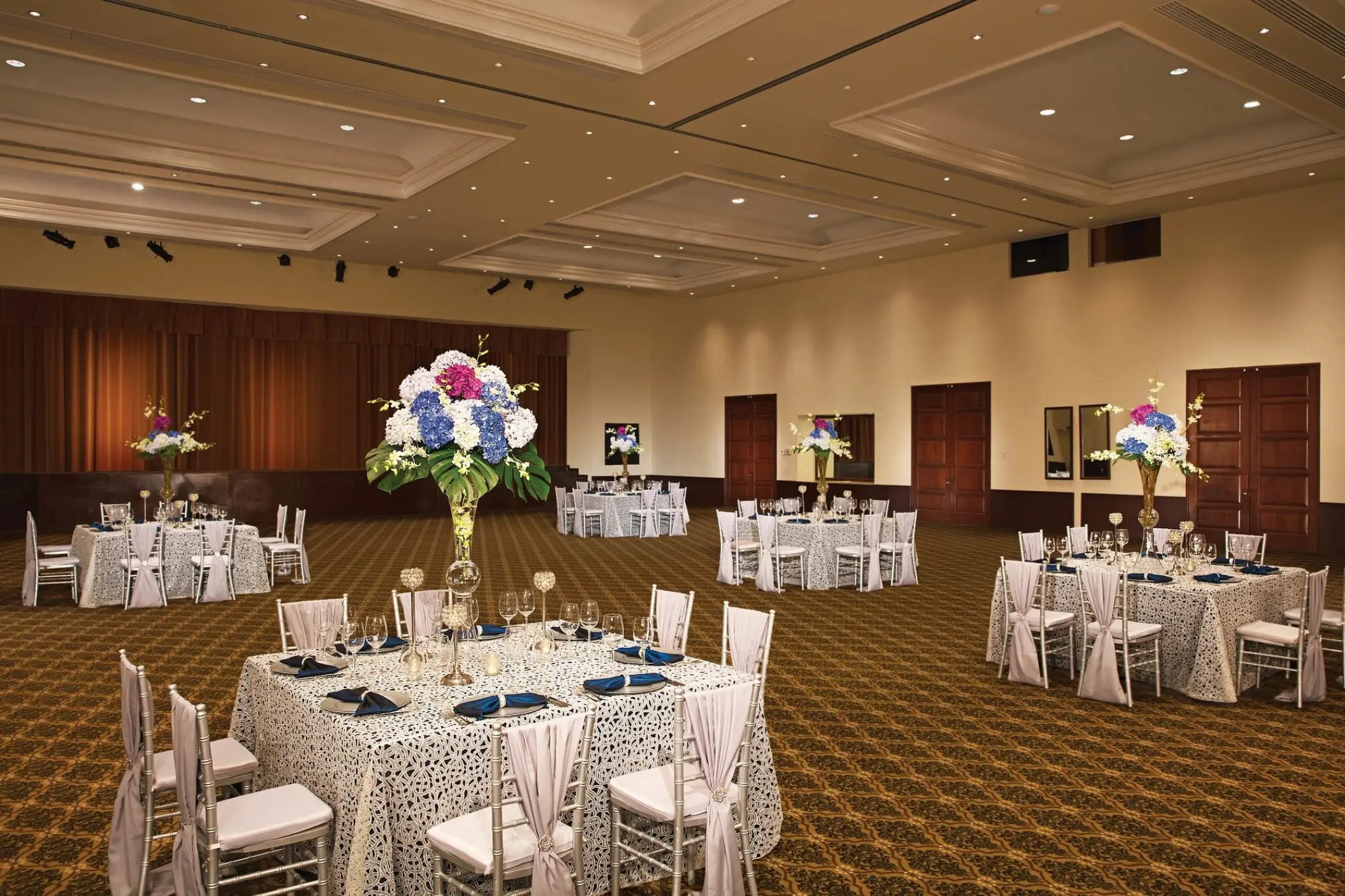 Indoor wedding reception with round tables and floral centerpieces at Dreams Tulum