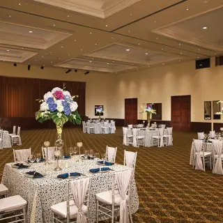 Indoor wedding reception with round tables and floral centerpieces at Dreams Tulum