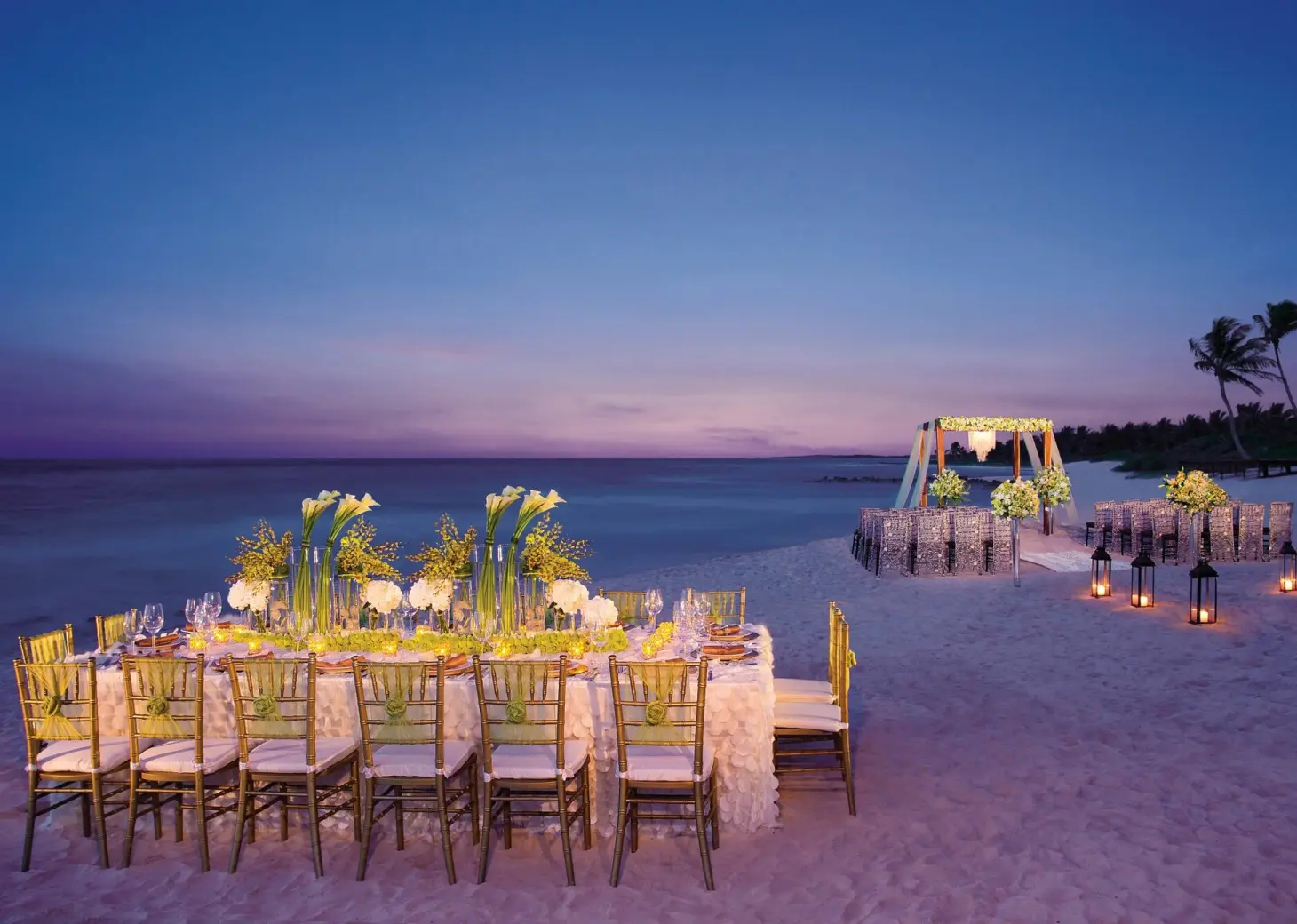 Beachfront wedding reception and ceremony setup at dusk at Dreams Tulum